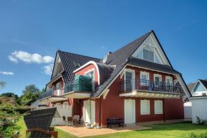 a red house with a black roof at Villa Sola Bona, FW 6 in Zingst