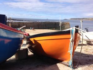 a yellow boat is tied up on the beach at Sennen Cove Retreat in Sennen Cove