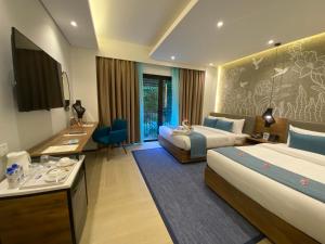 a hotel room with two beds and a desk at Fairways and Bluewater Boracay in Boracay