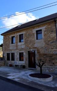 une maison en pierre avec un banc devant elle dans l'établissement Apartamento CATA Santiago de Compostela, à Saint-Jacques-de-Compostelle