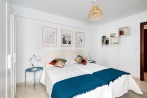 a white bedroom with a large bed and a table at La Francesa Triana in Seville
