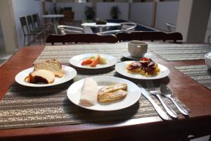 einem Holztisch mit Teller mit Lebensmitteln darauf in der Unterkunft Hotel Encanto do Sertão in Triunfo