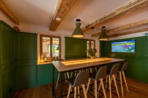 une cuisine verte avec une table et des chaises en bois dans l'établissement Landhotel Hochlackenhof, à Fuschl am See