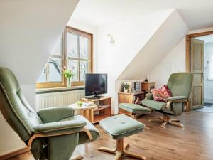 a living room with green chairs and a tv at Seenest Appartement 3 in Zingst