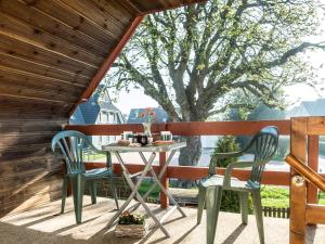 a table and chairs on a deck with a tree at Seenest Appartement 3 in Zingst