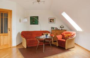 sala de estar con sofá naranja y 2 sillas en Fewo 2 "Landhaus am Grashof" en Offenbüttel
