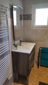 W łazience znajduje się umywalka i lustro. w obiekcie Maison 400m Océan avec jardin clos et ombragé w mieście Saint-Georges-dʼOléron