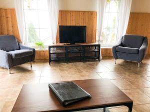 ein Wohnzimmer mit 2 Stühlen und einem Flachbild-TV in der Unterkunft Ferienwohung in Dresden am Elbhang in Dresden