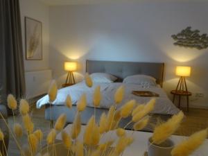 ein Schlafzimmer mit einem Bett mit gelben Blumen im Vordergrund in der Unterkunft Küstenperle in Grömitz
