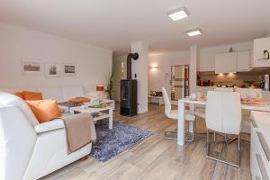 a living room and kitchen with a couch and a table at Les Belles, Haus Bastien, FW Charmant, Whg 7 in Zingst
