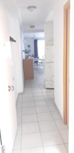 um corredor com piso em azulejo branco num quarto em BONAIRE em Sitges