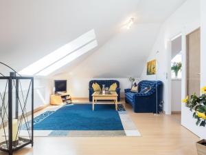 a living room with blue furniture and a blue rug at Likedeeler Weg 1 Whg 23 in Zingst