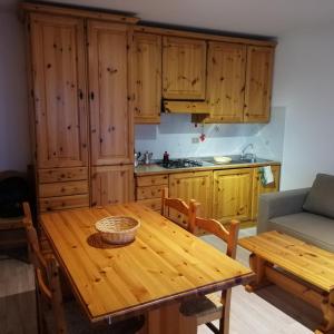 a kitchen with a wooden table and wooden cabinets at IL RISVEGLIO in Sella Nevea