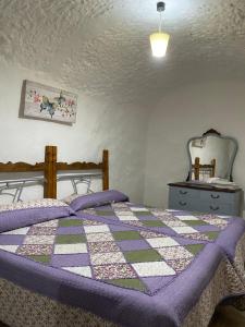 1 dormitorio con 1 cama con edredón en Cuevas Uropia, en Graena