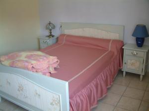 una camera da letto con un letto con una coperta rosa sopra di les lavandes a Montjay