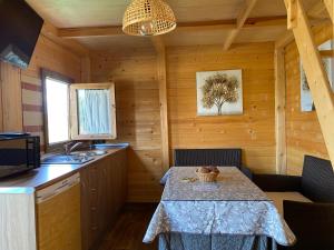 una cocina con mesa en una cabaña de madera en Alojamiento Rural Setenil, en Setenil