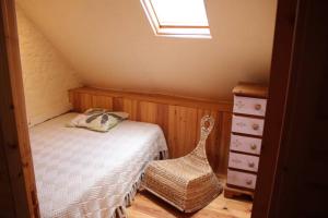 ein kleines Schlafzimmer im Dachgeschoss mit einem Bett und einer Kommode in der Unterkunft Bras D’Or Rural Gite cottage by farms & lakes. in Bais