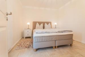 a bedroom with a bed with two lamps on it at Whg 05 - Boddenangler in Zingst