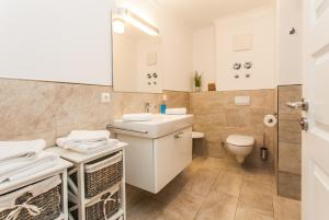 a white bathroom with a sink and a toilet at Whg 05 - Boddenangler in Zingst