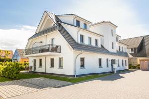 a white house with a black roof at Whg 05 - Boddenangler in Zingst