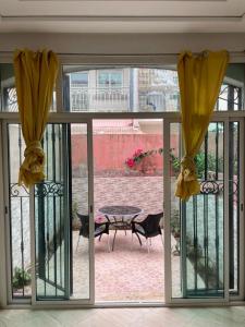 d'une porte coulissante en verre avec une table et une terrasse. dans l'établissement Duplex sidi bouzid, à Sidi Bouzid