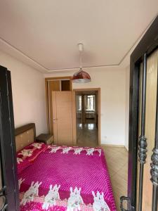 - une chambre avec un lit rose dans l'établissement Duplex sidi bouzid, à Sidi Bouzid