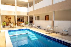 a pool with chairs and a table and a table and chairs at Hotel Encanto do Sertão in Triunfo