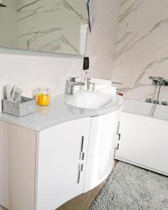 ein weißes Badezimmer mit einem Waschbecken und einer Badewanne in der Unterkunft Feudo di Castelmozzo in Santa Paolina