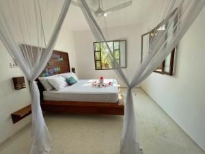 a bedroom with a large bed and a large window at Gaia Villas in Nungwi