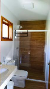 a bathroom with a shower and a toilet and a sink at Pousada Sítio Vale das Olivas in Aiuruoca