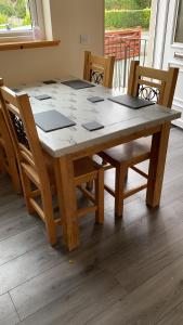 a wooden table with chairs and a table and a table at Tigh Murdag, 37D Newmarket HS2 0DT in Stornoway