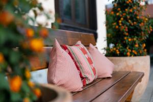 2 almohadas rosas sentadas en un banco de madera en Hotel Garni Bergidyll - adults only en Pfronten