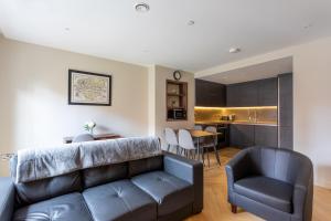 a living room with a couch and a kitchen at Kings apartments, Hudson Quarter in York