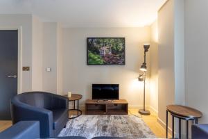 a living room with a couch and a television at Kings apartments, Hudson Quarter in York