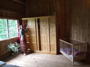 a woman standing in a room with a crib at Scheune in Kirch Mulsow