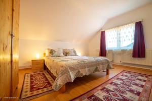 a bedroom with a bed and a window at Pensiunea Baron Bazna in Bazna