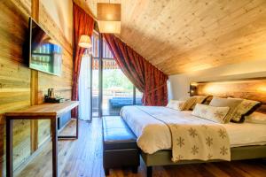 a bedroom with a large bed with a wooden ceiling at Hôtel Neste de Jade in Saint-Lary-Soulan +36 photos