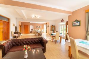 a living room with a couch and a dining room at Pensiunea Baron Bazna in Bazna