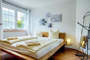 a bedroom with a bed with white sheets and a window at Lüdtke, Bent in Zingst