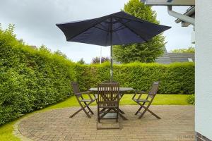 a table and chairs with an umbrella on a patio at Lüdtke, Bent in Zingst