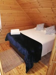 a bedroom with a bed in a wooden cabin at Chalé 41 in Cortes do Meio