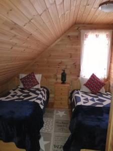 a bedroom with two beds in a log cabin at Chalé 41 in Cortes do Meio