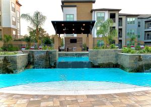 einem Pool mit blauem Wasser vor einem Gebäude in der Unterkunft Pristine Apt-King Bed-Access to 3 Las Vegas Pools! in Bryan