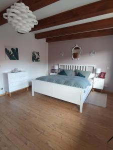 a bedroom with a large white bed and two night stands at Domizil an der Huysburg in Dingelstedt