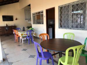 a dining room with colorful chairs and tables at Oncotô Palmas Hostel in Palmas