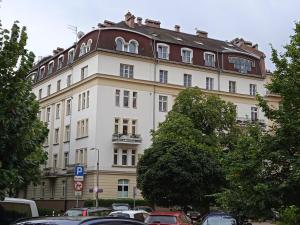a large white building with a brown roof at Green Wood Apartament Stara Ochota in Warsaw