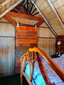 a bedroom with a bed in a wooden cabin at Los diablitos in Punta Del Diablo