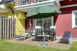 ツィングストにあるVilla Arielle, FW 2の家の前にテーブルと椅子、傘