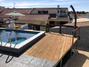 een houten terras met een zwembad en een huis bij Sun house - Near Sintra - Kitchen - Pool in Sintra