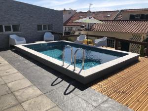een zwembad op een terras met stoelen en een parasol bij Sun house - Near Sintra - Kitchen - Pool in Sintra